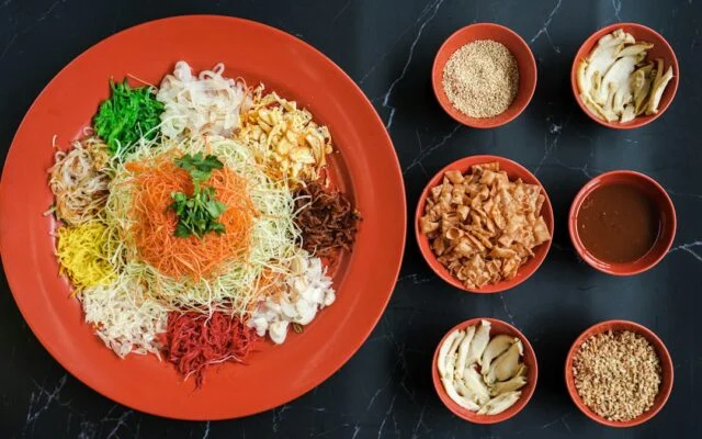 Yu sheng prosperity salad with its toppings in small bowls